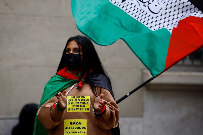 A student holds a Palestinian flag as they gather near the Sorbonne University in support of Palestinians in Gaza