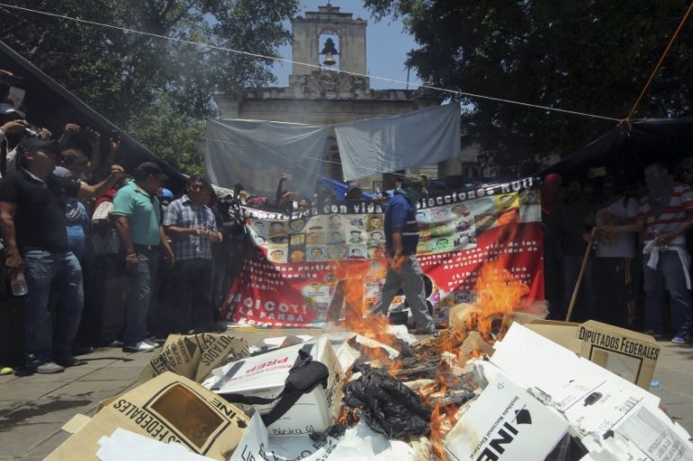 CNTE members gather around burning electoral materials in downtown Oaxaca