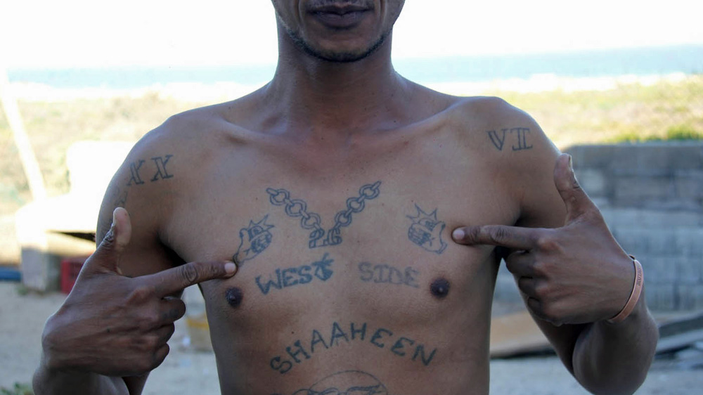 Tathir Kelly displays his gang tattoos [Dariusz Dziewanski/Al Jazeera]