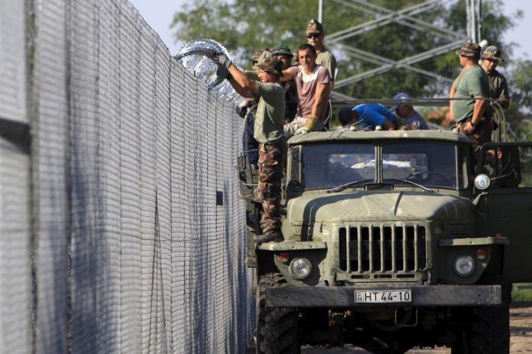 Hungarian soldiers adjust the razor wire on a fence near the town of Asotthalom