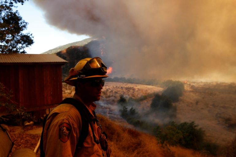 Firefighters protect homes during the Blue Cut Fire in San Bernardino County, California