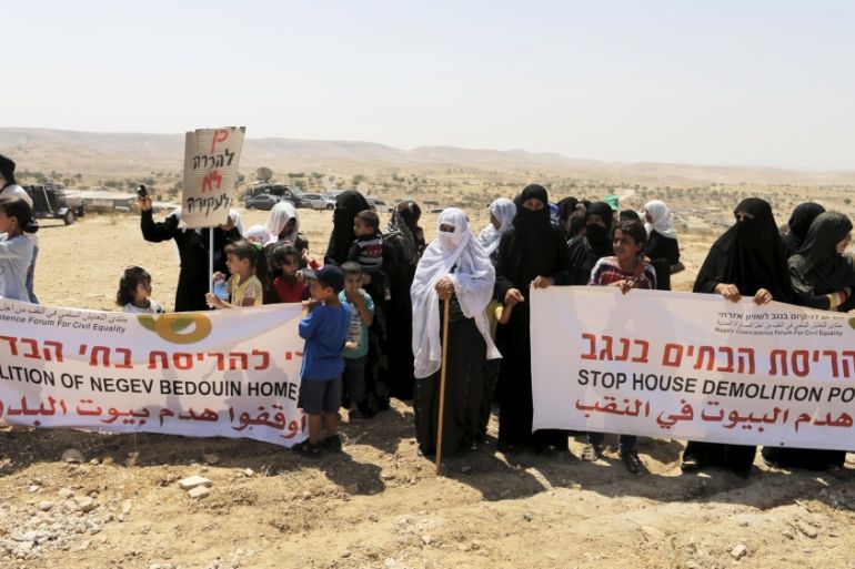 Women, residents of the Umm Al-Hiran, a Bedouin village which is not recognised by the Israeli government, hold banners during a protest in Israel''s southern Negev desert