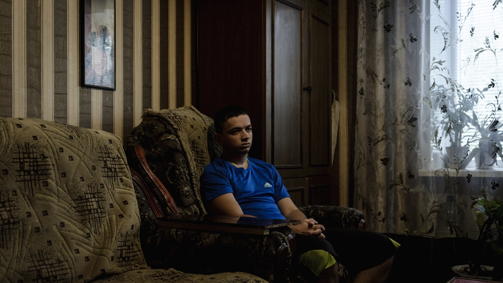 Konstantine Zarubin sits in his grandparents' home - two floors below the home of his best friend, Edek. Two years ago, Edek was killed by a landmine as the boys climbed in a quarry [Benas Gerdziunas/Al Jazeera]