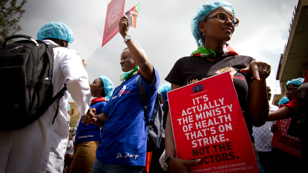 On January 31, outside the courthouse in Nairobi which is deciding whether doctors may continue their strike, doctors carried signs blaming the health ministry for the untold number of patients who aren't receiving treatment as the standoff between the medical union and the ministry drags on. [Jacob Kushner/Al Jazeera] 