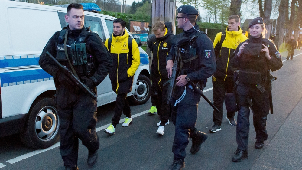 Borussia Dortmund players, left to right, Nuri Sahin, Marcel Schmelzer and Sven Bender escorted by police [EPA]