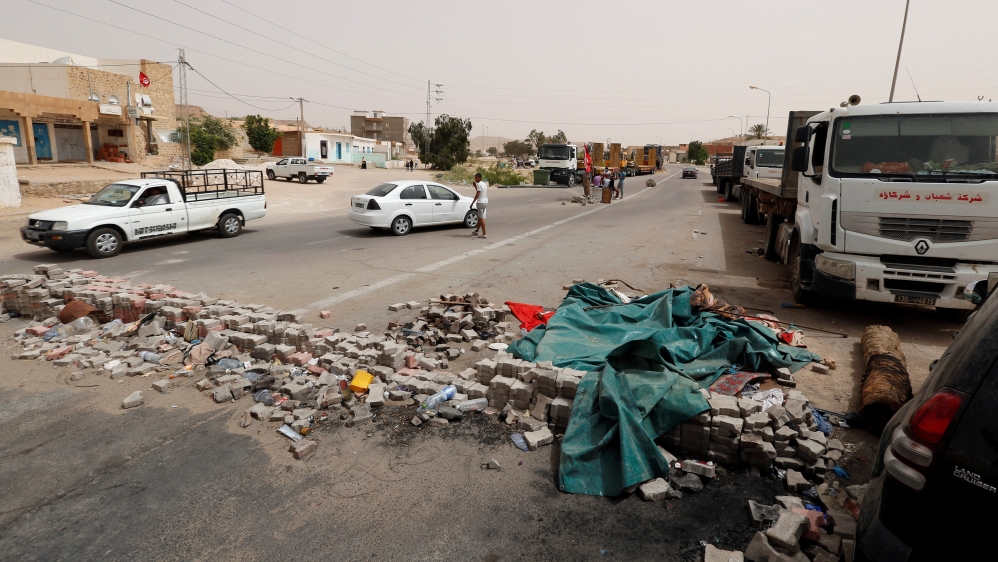 Protesters, who are demanding jobs and a share in revenue from the area's natural resources, block the roadusually used by foreign oil companies [Zoubeir Souissi/Reuters]