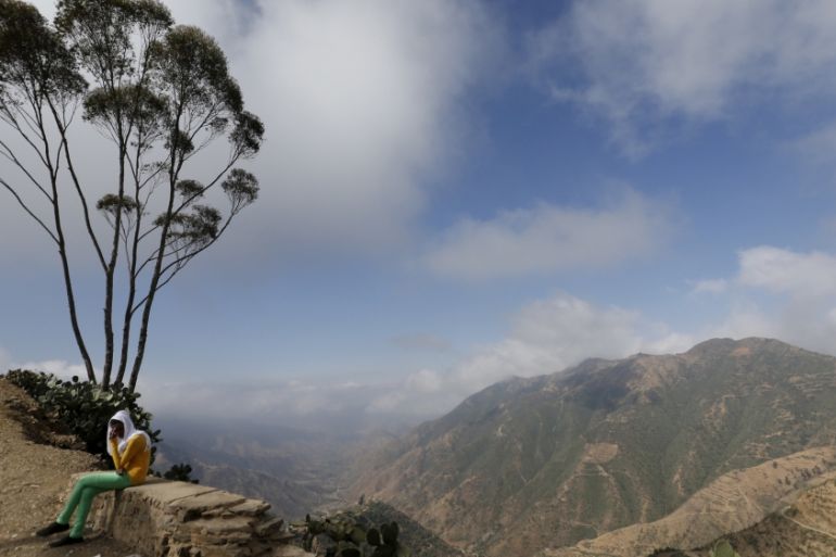A woman sits next to an escarpment on the outskirts of Asmara, Eritrea