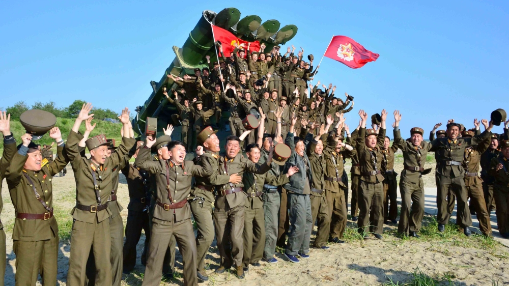 Members of the Korean People's Armed Forces react after doing a test-fire of new cruise rocket [Reuters]
