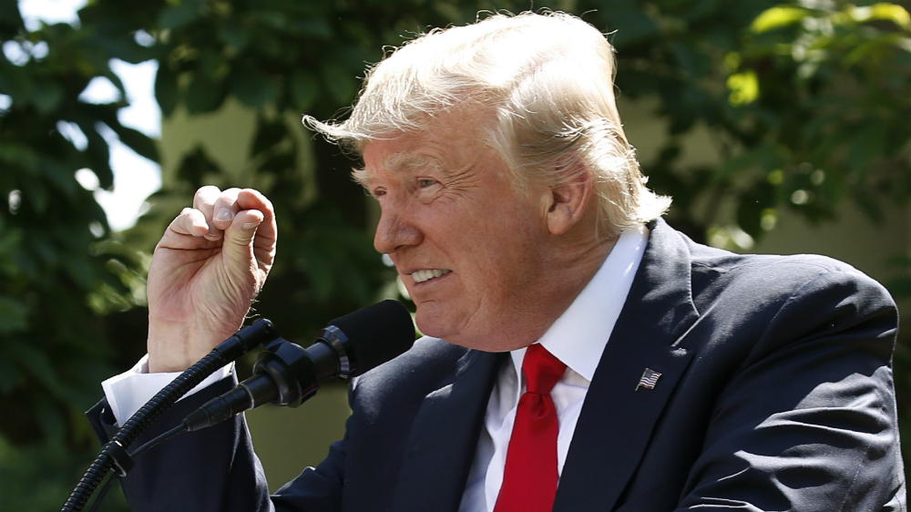 US President Donald Trump gestures to show the extent of temperature change he thinks there is, as he announces his decision to withdraw from the Paris Climate Agreement [Joshua Roberts/Reuters]
