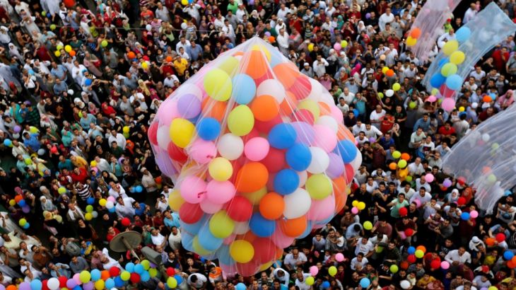 Egyptians wait to catch balloons after Eid al-Fitr prayers in Cairo