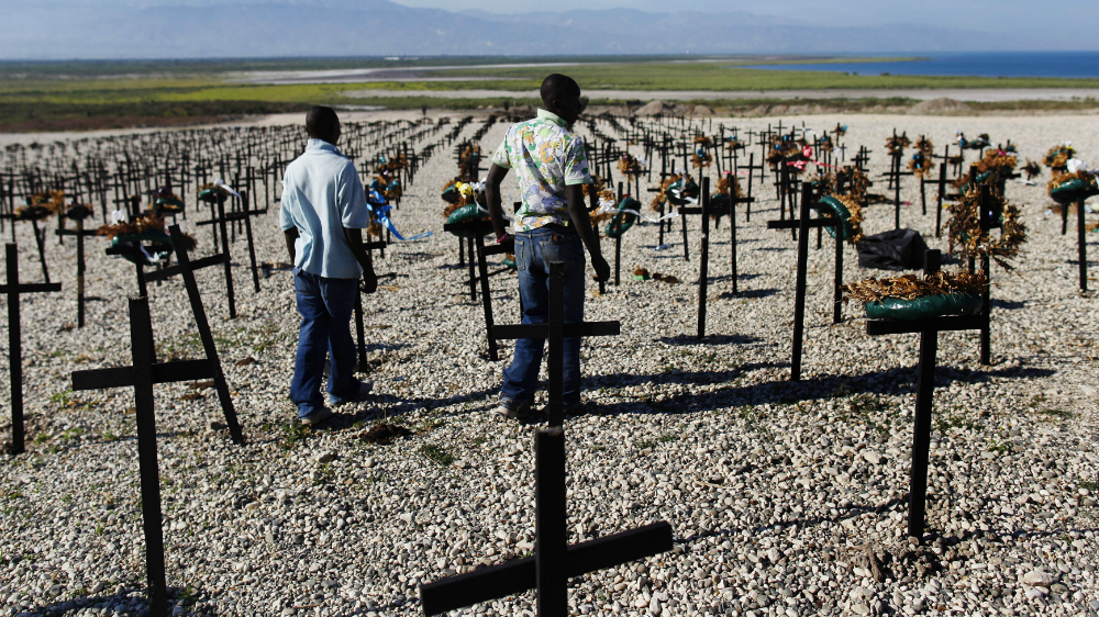 Men who lost relatives in the 2010 earthquake visit the mass grave site in Titanyen on the outskirts of Port-au-Prince [Shannon Stapleton/Reuters]