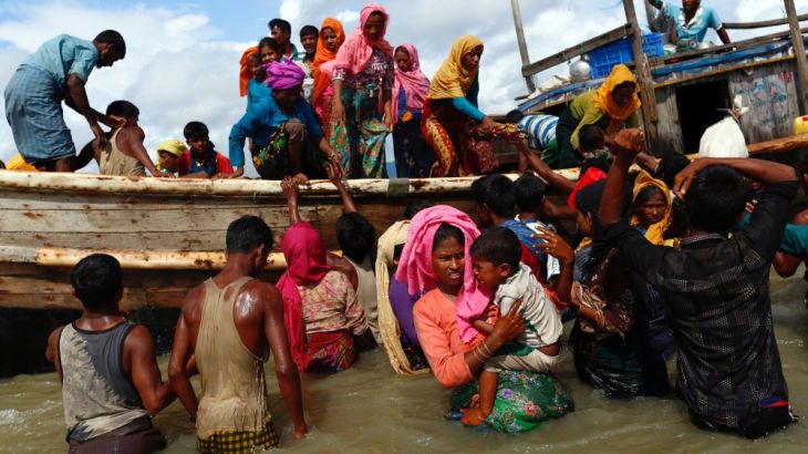 Rohingya refugees get off a boat after crossing the Bangladesh-Myanmar border through the Bay of Bengal, in Shah Porir Dwip