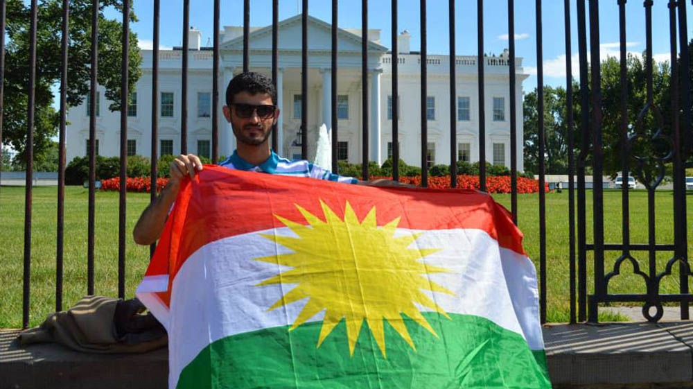'Yes' voter Baxtiyar Goran holds a 'Kurdistan' flag outside the White House building in Washington, DC [Baxtiyar Goran/Al Jazeera]