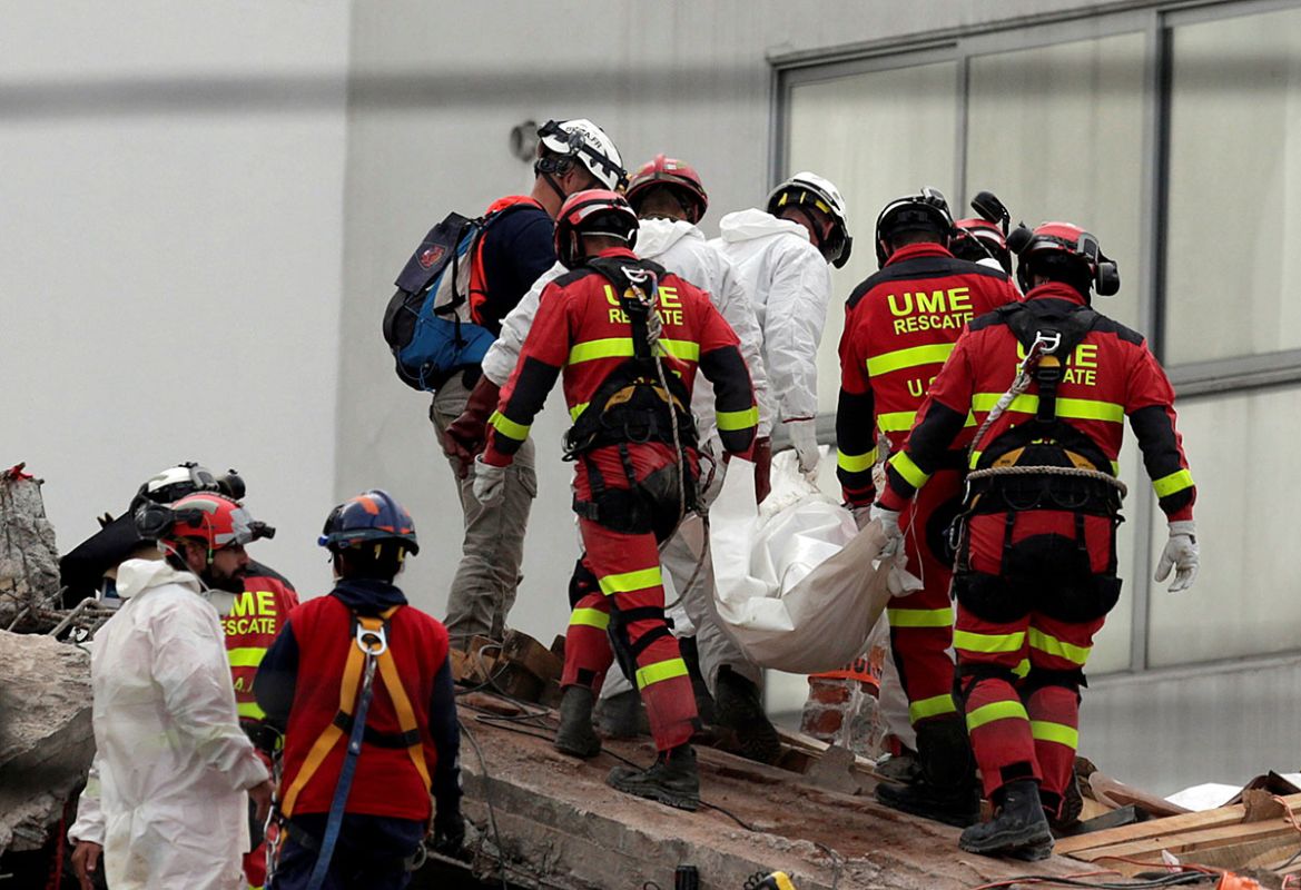 Rescue teams carry a body recovered from the rubble. REUTERS/Daniel Becerril