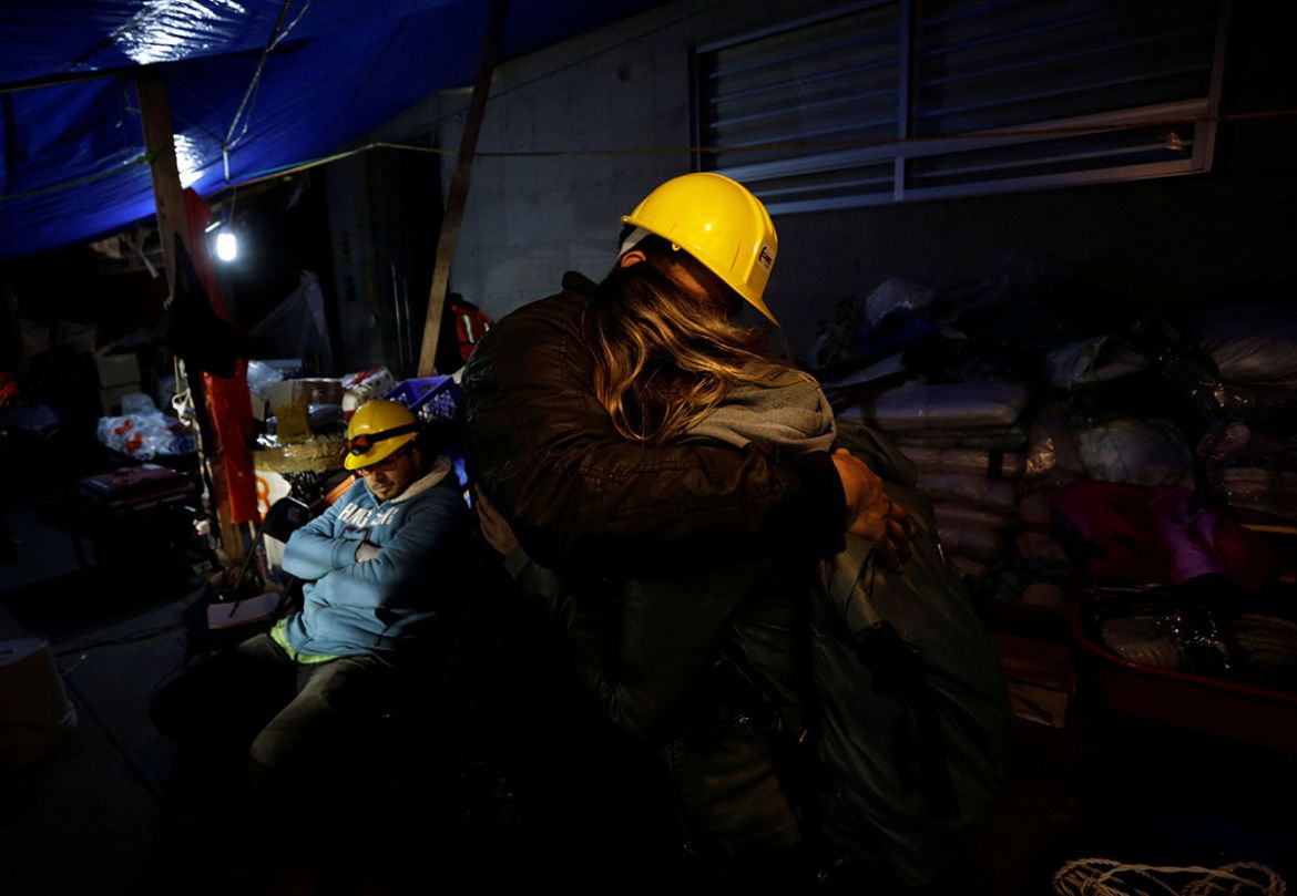 Volunteers hug after rescue teams retrieved the last body trapped in the rubble of a building in Mexico City. REUTERS/Daniel Becerril