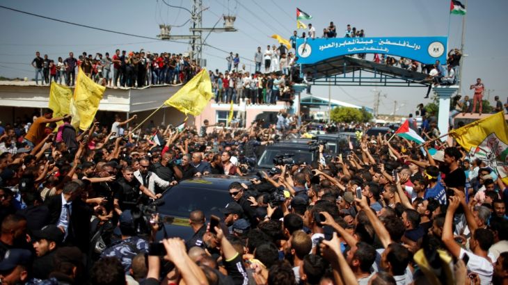 People gather as the convoy of Palestinian Prime Minister Rami Hamdallah and his government ministers arrive to take control of Gaza from the Islamist Hamas group, in the northern Gaza Strip