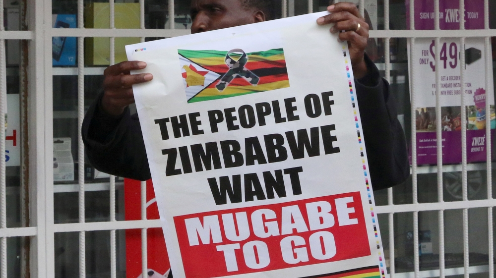 A man carries a poster calling for Mugabe to step down [Philimon Bulawayo/Reuters]