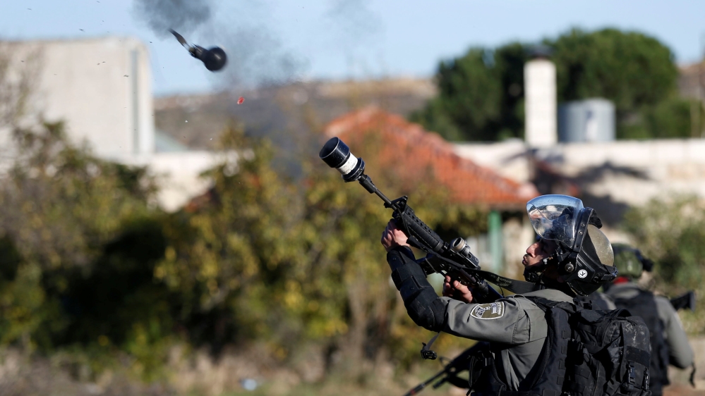 An Israeli border guard fires a tear gas grenade towards Palestinians near the illegal Jewish settlement of Beit El [Mohamad Torokman/Reuters]