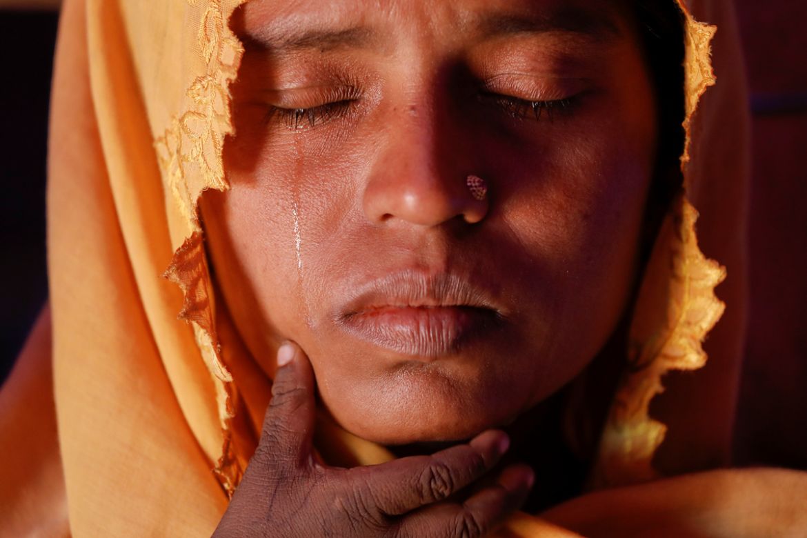 Roshid Jan, a Rohingya refugee cries holding her son Muhammad Gyab at their shelter at the camp for widows and orphans inside the Balukhali camp near Cox''s Bazar, Bangladesh. [Damir Sagolj/Reuters]