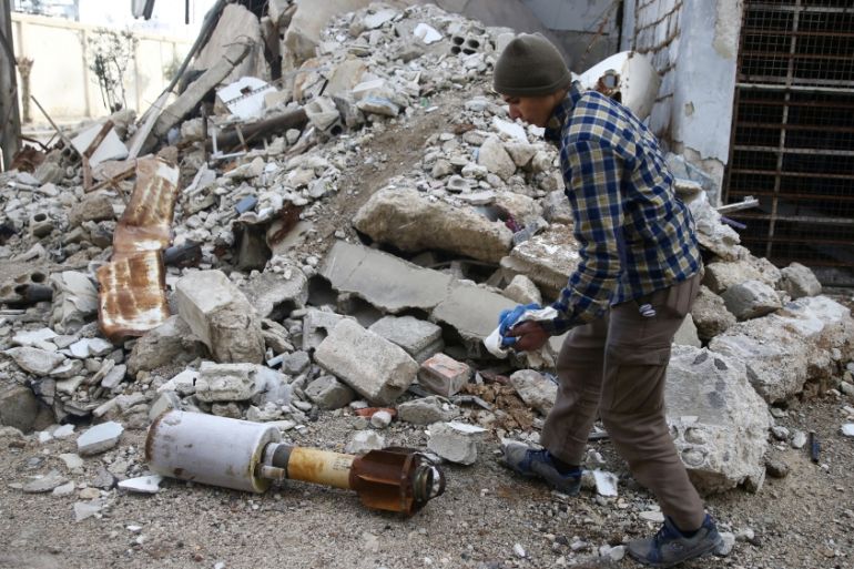 A man is seen near the remains of a rocket in Douma