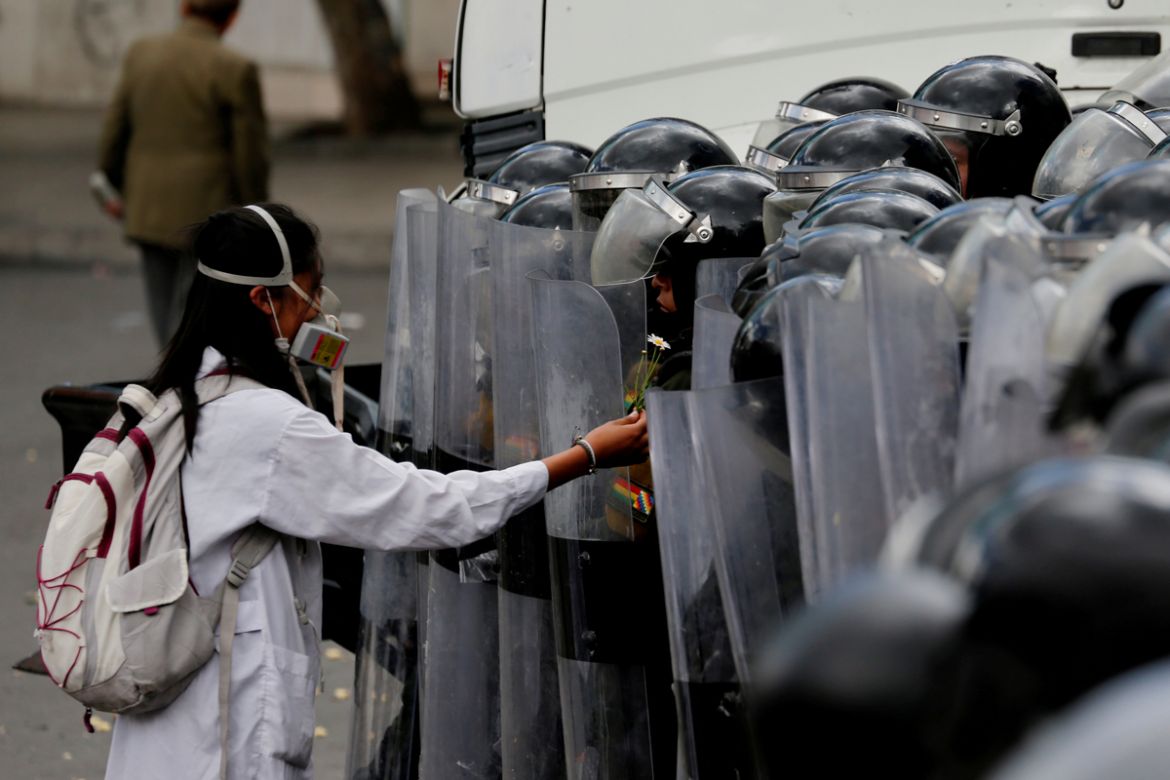 A demonstrator gives a flower to a riot police officer during a rally protest against Bolivia''s government new health care policies in La Paz, Bolivia, January 4, 2018. REUTERS/David Mercado TPX IMAGE