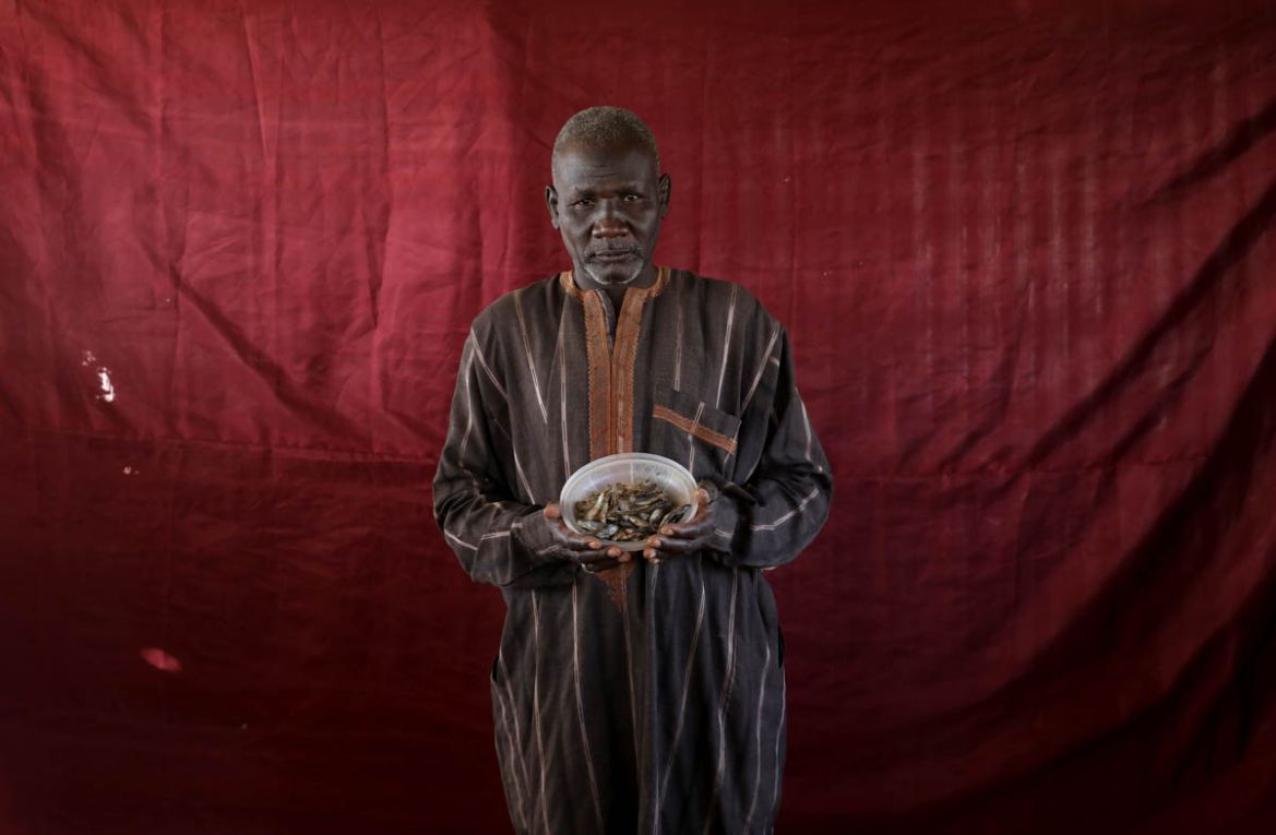 Abdulwahal Abdulla, a 50-year-old living in Bakasi for three years, hoped to trade this bowl of dried young tilapia fish worth roughly 150 naira for cooking oil. Abdulla, no fan of the fish, had bough