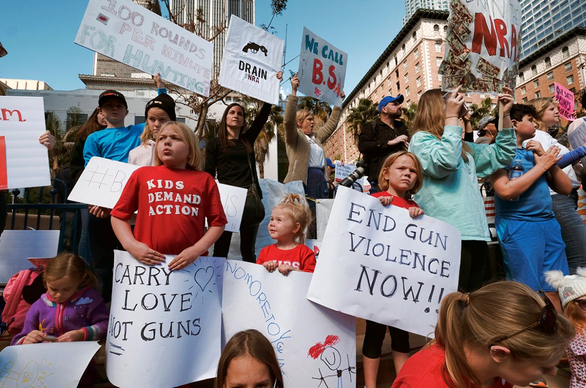 Children join their parents during a protest rally against gun violence in downtown Los Angeles on Monday, Feb. 19, 2018. Hundreds of sign-carrying, chanting protesters have converged on a downtown Lo
