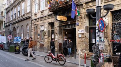 Tourists walk out of Szimpla, one of Budapest's most famous ruin pubs in the party district 
