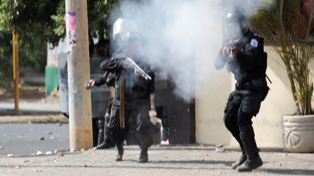 Riot police use tear gas on demonstrators [Oswaldo Rivas/Reuters]