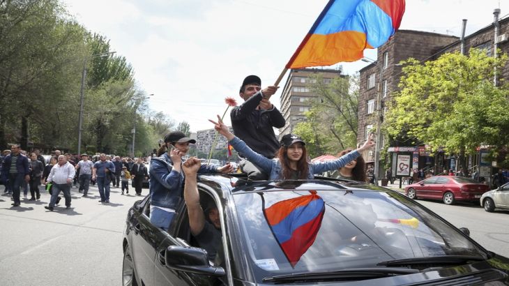 A young man waves an Armenian national flag as demonstrators march in protest against the appointment of former President Serzh Sargsyan as the new prime minister, in Yerevan [Aram Kirakosyan/AP]