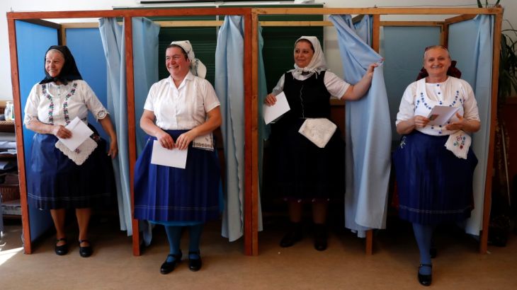 Hungarian women, wearing traditional costumes, leave a voting booth at a polling station during Hungarian parliamentary elections in Veresegyhaz