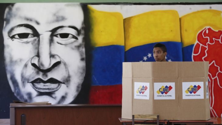 A voter chooses his candidate next to a mural of late Venezuelan President Hugo Chavez during presidential elections in Caracas, Venezuela, Sunday, May 20, 2018. [Ariana Cubillos/AP]