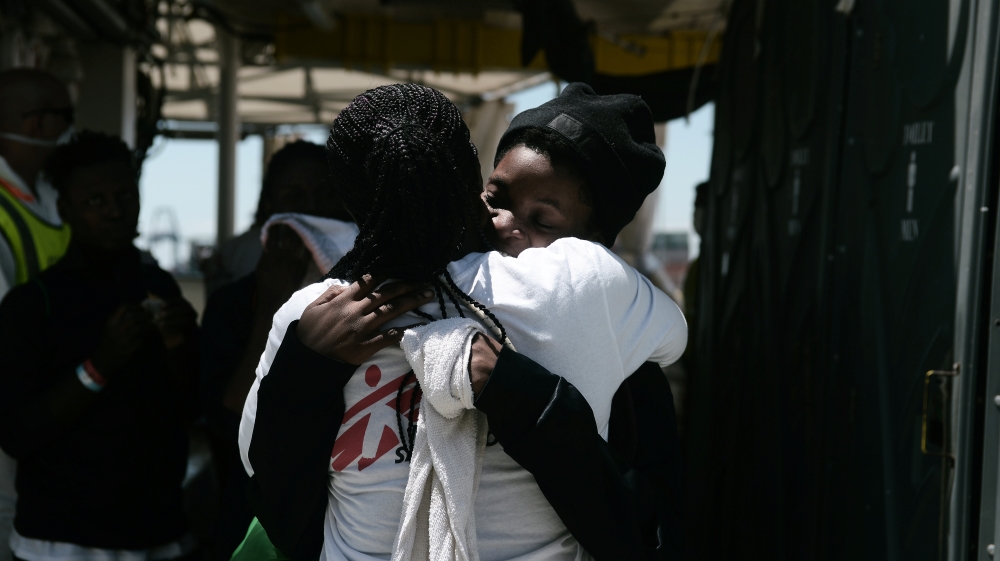 A migrant hugs a crew member before disembarking from the Aquarius rescue in Valencia [Kenny Karpov/SOS Mediterranee via Reuters]