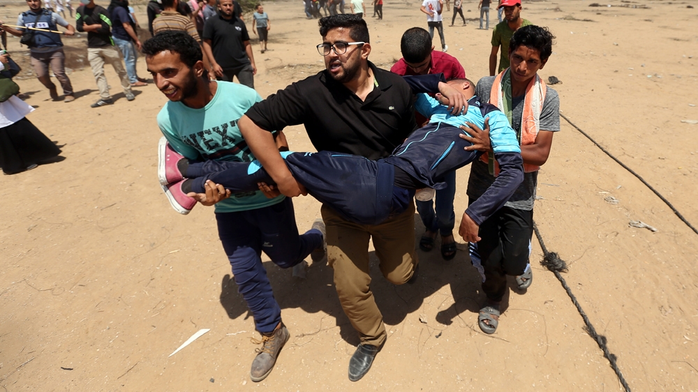 A wounded Palestinian demonstrator being evacuated [Ibraheem Abu Mustafa/Reuters]