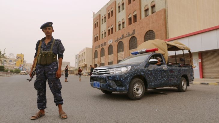 Pro-Houthi police trooper stands past a patrol vehicle in the Red Sea port city of Hodeidah