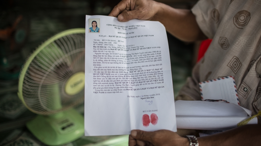 Sang, 53, shows a letter he wrote to the Saudi Embassy in Vietnam and the Vietnamese Embassy in Saudi Arabia, detailing the family situation [Yen Duong/Al Jazeera]