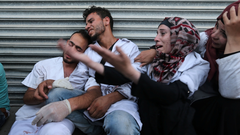 Colleagues of slain Palestinian medic react at a hospital in southern Gaza Strip [Ibraheem Abu Mustafa/Reuters]