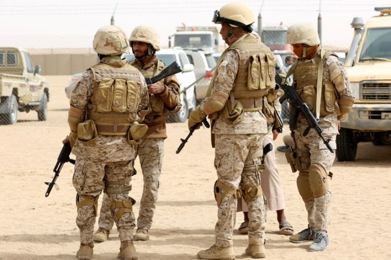 Saudi troops stand at an airfield, where Saudi cargo planes delivered aid, in the northern province of Marib