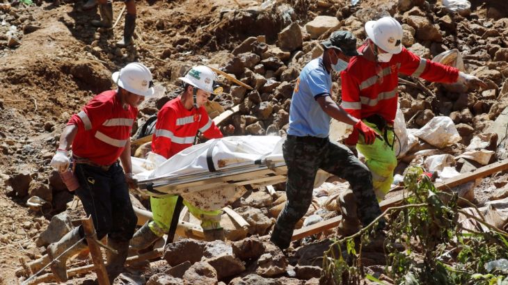 Rescuers carry on a stretcher a cadaver bag containing a body recovered in a landslide caused by Typhoon Mangkhut at a small-scale mining camp in Itogon