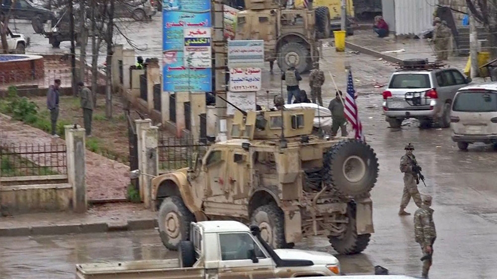 A screen grab taken from video shows US troops gathered at the scene of the attack [ANHA/AFP]