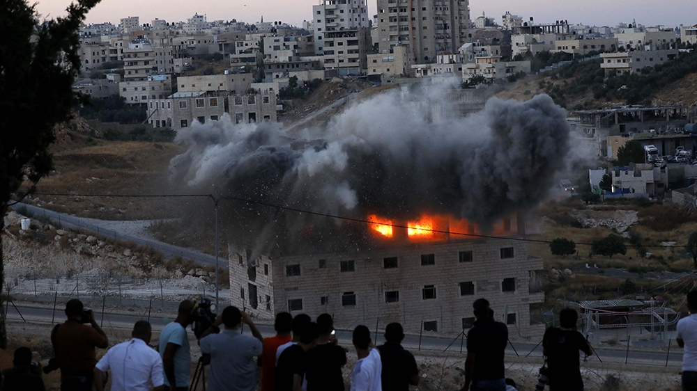 A Palestinian building is blown up by Israeli forces in the village of Sur Baher which sits on both sides of the Israeli barrier in East Jerusalem and the Israeli-occupied West Bank, 22 July 2019. Isr