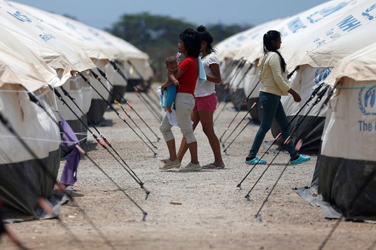 Venezuelan migrant women walk through a camp run by the UN refugee agency UNHCR in Maicao, Colombia