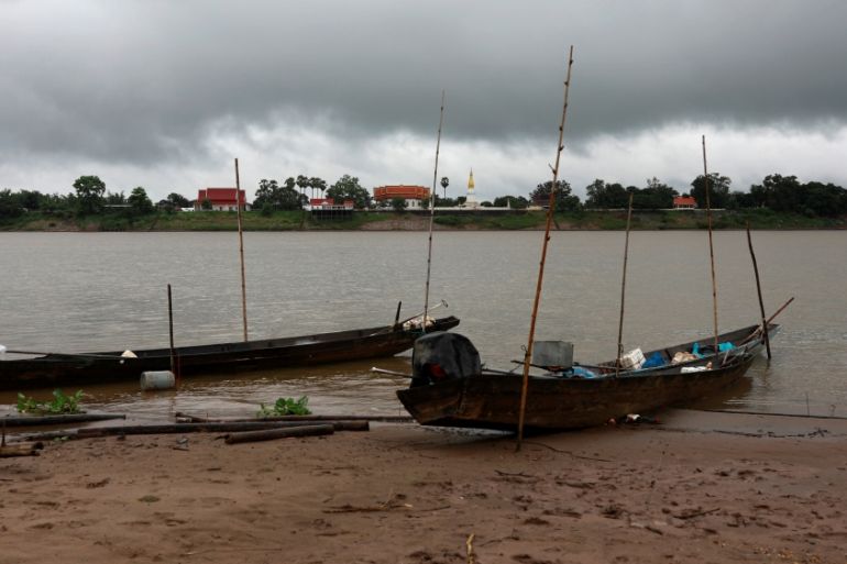 Pagoda from Laos is seen under a rain cloud from across the Mekong River in Nakhon Phanom