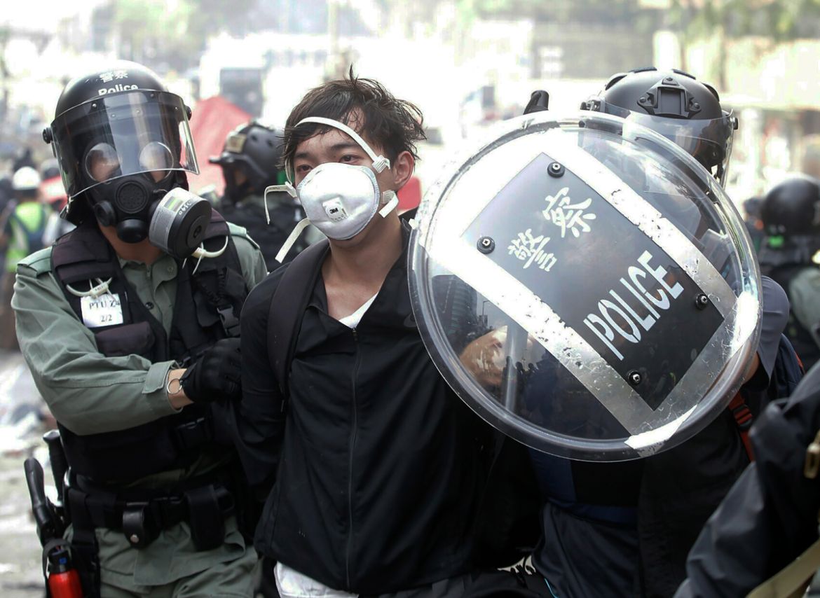 Police officers detain a protestor near the Hong Kong Polytechnic University in Hong Kong, Monday, Nov. 18, 2019. Hong Kong police have swooped in with tear gas and batons as protesters who have taken