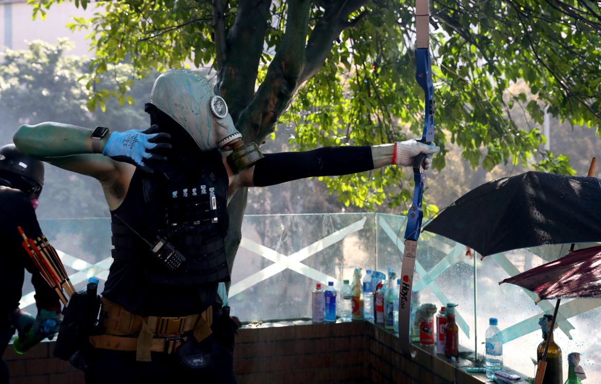 An anti-government protester uses a bow during clashes with police outside Hong Kong Polytechnic University (PolyU), in Hong Kong, China, November 17, 2019. REUTERS/Athit Perawongmetha