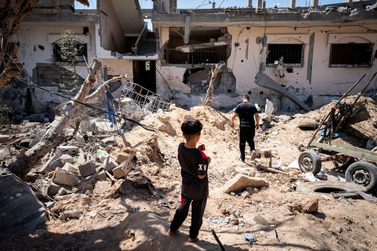 A child stands in a clearing strewn with debris from an Israeli air attack during the 11-day offensive on Gaza