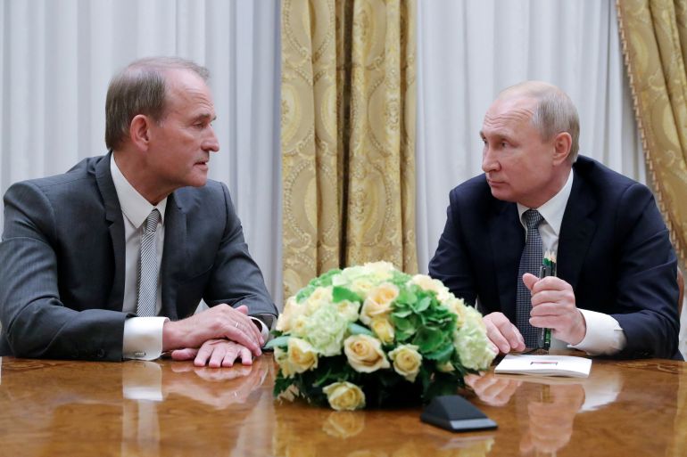 Russian President Vladimir Putin sits with Ukrainian politician Viktor Medvedchuk