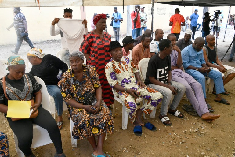 Voters sit as they wait to vote 