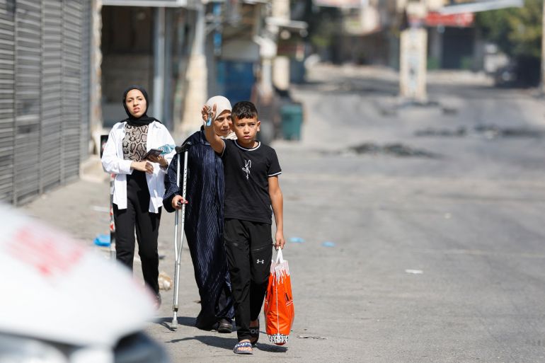 Palestinians walk during an Israeli military operation in Jenin, in the Israeli-occupied West Bank July 3, 2023. REUTERS/Mohamad Torokman