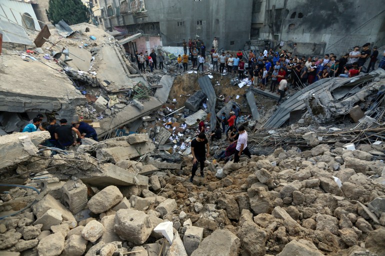 Palestinians inspect the site of a Greek Orthodox church, destroyed following Israeli airstrikes